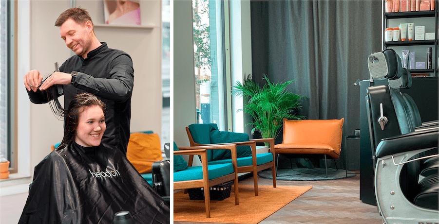The image is divided into two parts: on the left is a hairdresser cutting a smiling customer sitting with a haircut, and on the right is part of the salon's interior with black barber chairs, a mustard yellow armchair, and a green plant in front of dark curtains. The atmosphere is both professional and inviting.