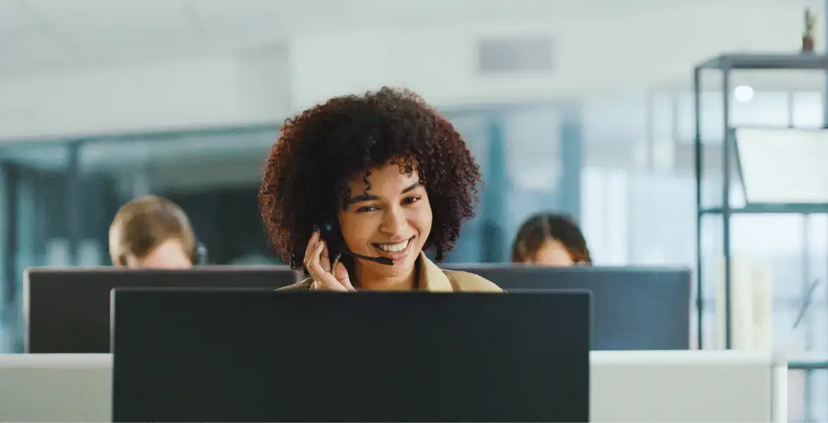 Woman with headset looking at computer screen in an office setting
